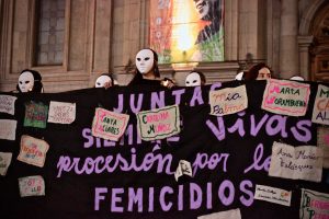 Feministas recuerdan a víctimas de femicidios marchando por el paseo Ahumada enmascaradas