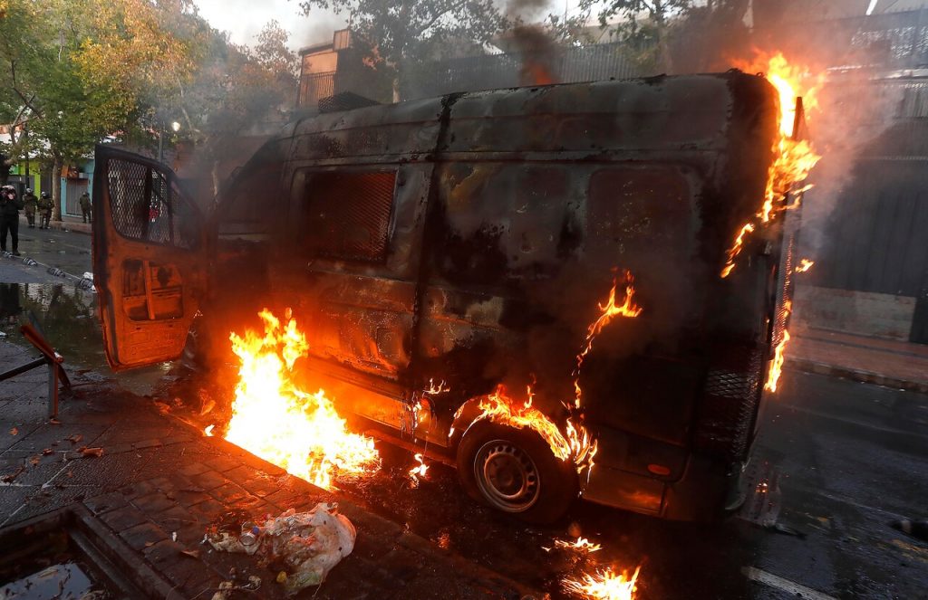 Carro de Carabineros arde en llamas durante manifestaciones en la Plaza Dignidad
