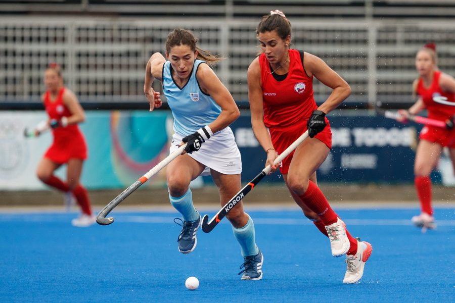 Una jugadora de la selección femenina de hockey césped se disputa la bocha con una jugadora uruguaya.