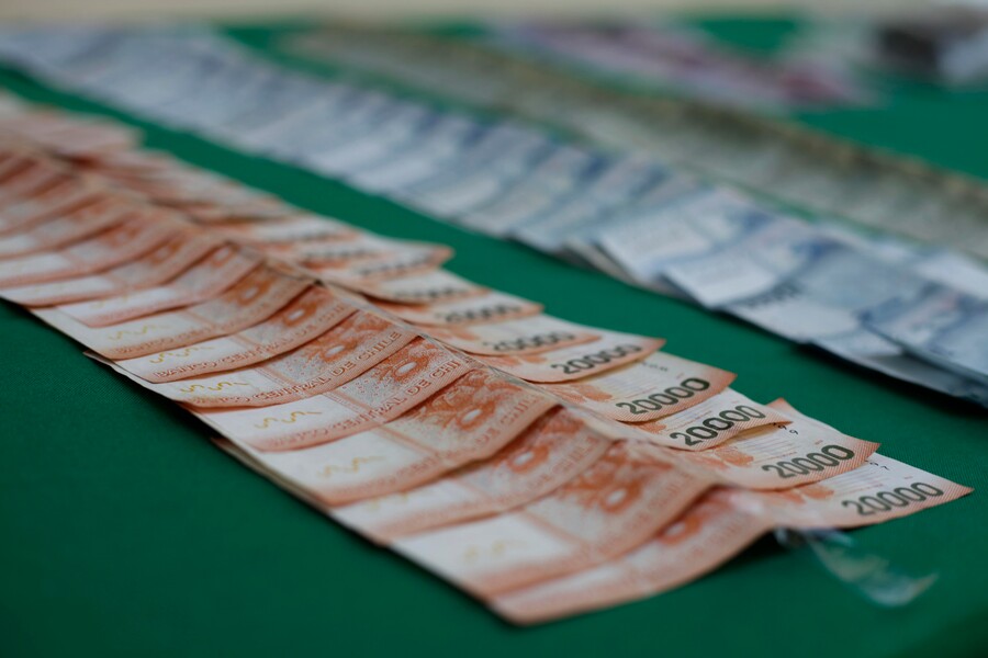 Billetes de 20 mil y 10 mil pesos, puestos en una mesa como evidencia incautada por la PDI
