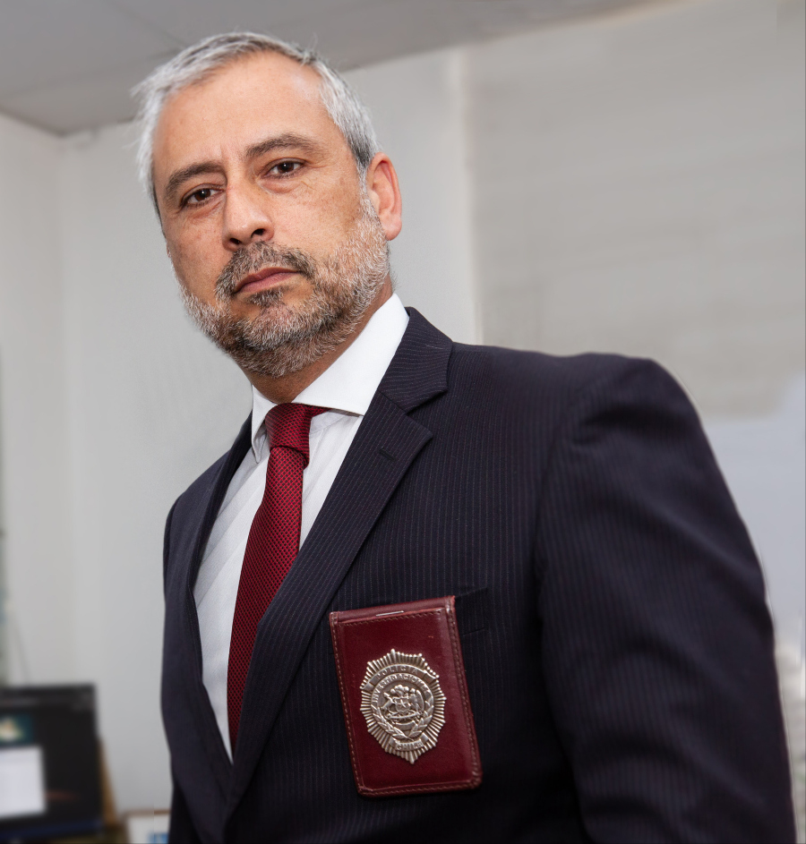 Retrato de plano medio del prefecto inspecto Paulo Contreras. Vestido de terno y corbata, con su placa policial.