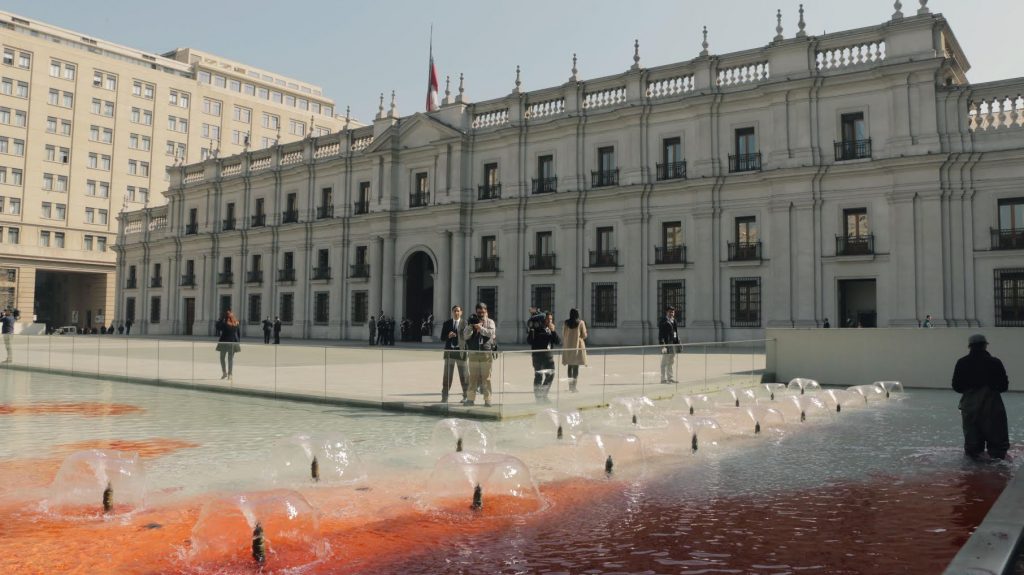 Día del detenido desaparecido: Londres 38 protestó tiñendo de rojo las piscinas del frontis de La Moneda