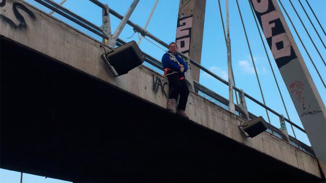 Mujer protesta colgada a un puente en pleno centro de Santiago por cancelación de permiso para su negocio
