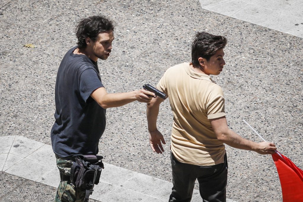 FOTOS| Adherente a Pinochet apunta con un arma a civiles a pasos de La Moneda