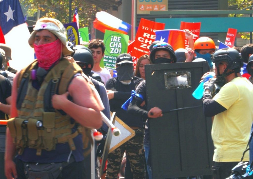 Partidarios del rechazo marchan encapuchados, con cascos, chalecos antibalas y escoltados por Carabineros