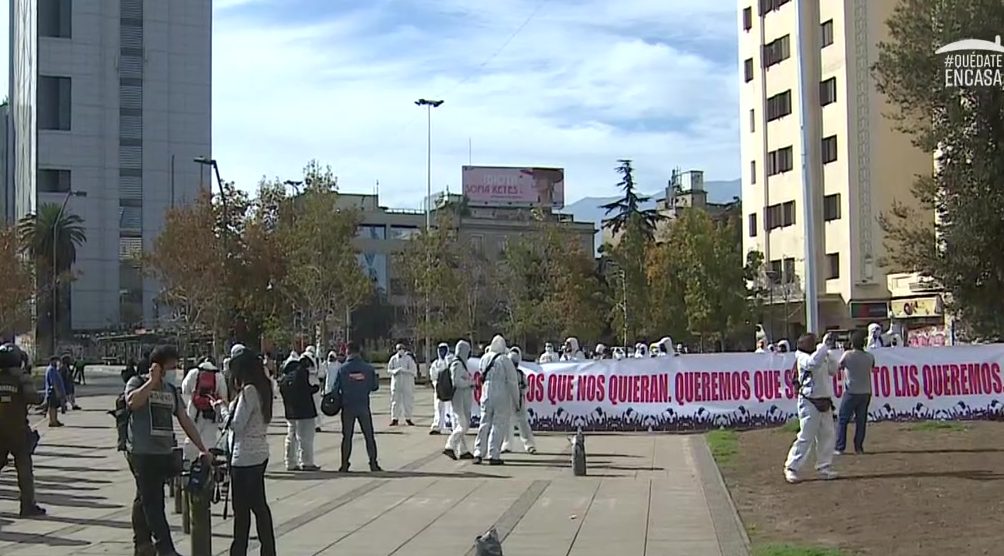 Manifestantes vestidos de overoles blancos llegan a Plaza de la Dignidad y despliegan llamativo lienzo
