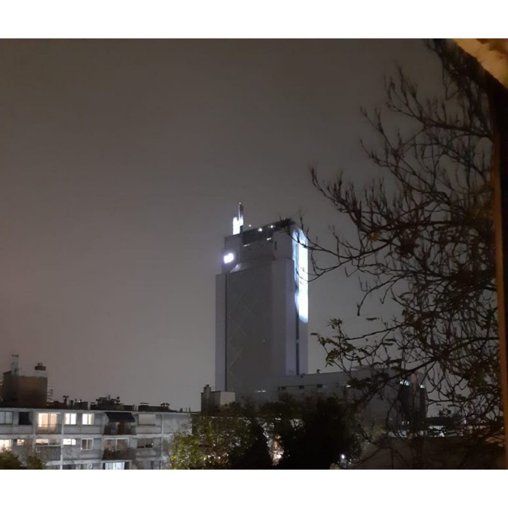 REDES| Potentes focos cubren proyección de palabras «Solidaridad» y «Humanidad» en costado del edificio Telefónica